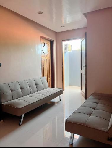 a living room with a couch and a table at Casa Rosita Beach Front House in Surigao