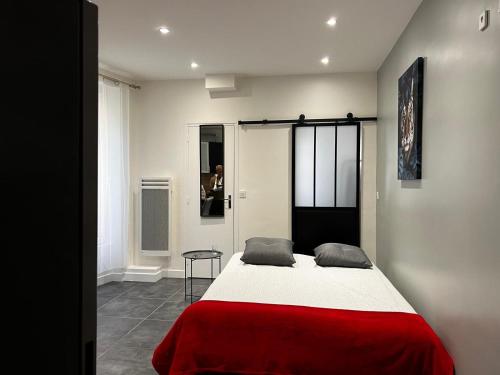 ein Schlafzimmer mit einem Bett mit einer roten Decke in der Unterkunft Appartement Paris - La Defense in La Garenne-Colombes