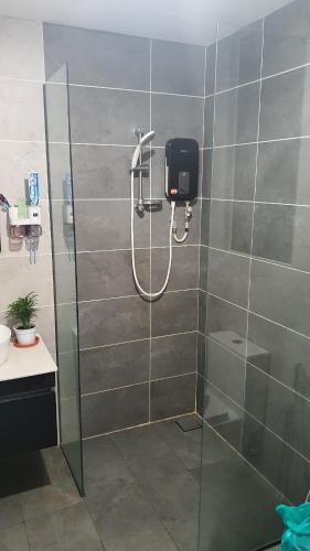 a shower in a bathroom with a glass door at Kami Tami Japandi Poolview in Putrajaya