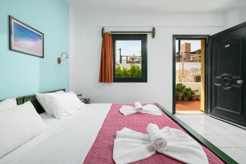 a bedroom with a white bed with bows on it at Elen-Mari in Hersonissos