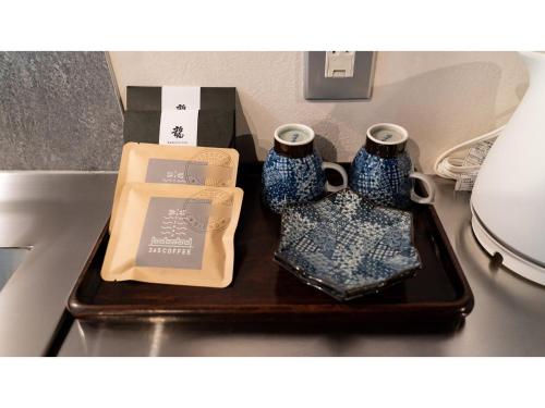ein Tablett mit zwei blauen Vasen auf einem Tisch in der Unterkunft Kominka Hotel kurasu - Vacation STAY 24275v in Tatsuno