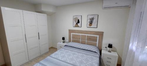 a small bedroom with a bed and white cabinets at Bravaholidays-602-Lloret Park 2 in Vidreres