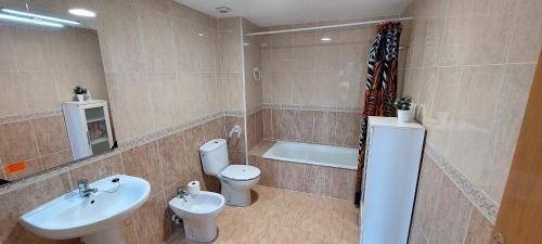 a bathroom with a sink and a toilet and a bath tub at Bravaholidays-602-Lloret Park 2 in Vidreres