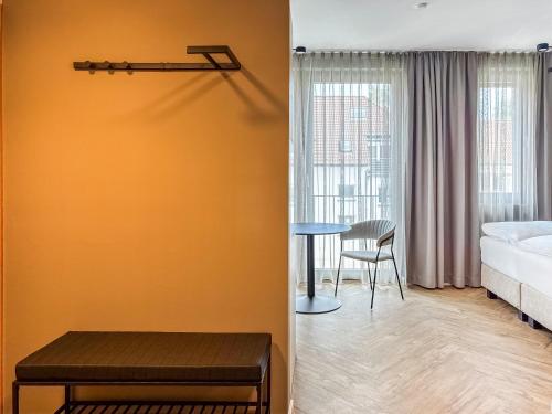 a room with a bed and a table and a bedroom at Townhome Hotel Hannover - Digital Access - kontaktloser Check-in in Hannover