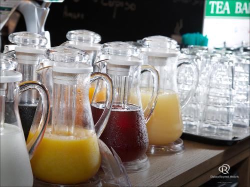 a group of glass containers filled with different types of juice at Daiwa Roynet Hotel Chiba Ekimae in Chiba
