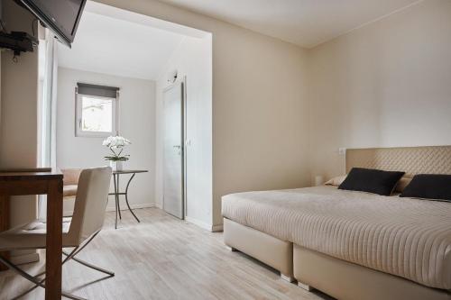 a bedroom with a bed and a table and a desk at Hotel Sole in Cannero Riviera