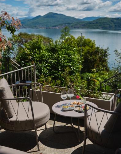a table and chairs on a balcony with a view of a lake at Hotel Sole in Cannero Riviera