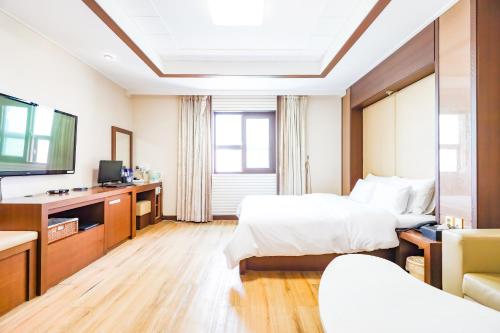 a hotel room with two beds and a flat screen tv at Hotel Charlot Castle in Pyeongtaek