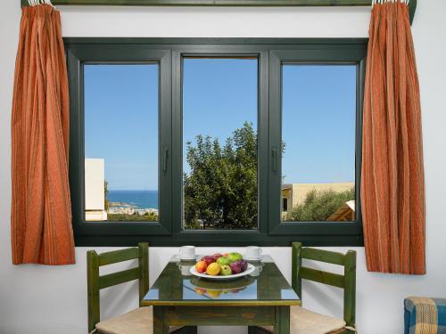 een tafel met een fruitschaal voor een raam bij Elen-Mari in Chersonissos
