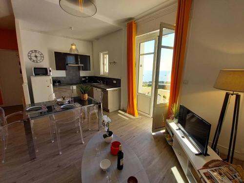 un salon avec une cuisine et un salon avec une table dans l'établissement Royan - VUE MAGIQUE pour cet APPARTEMENT au 1er étage - Résidence du Golf, à Royan