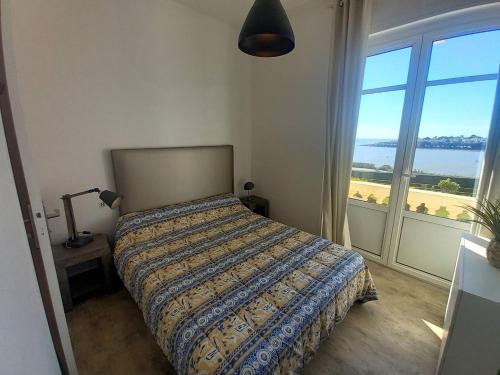 une chambre avec un lit avec vue sur l'océan dans l'établissement Royan - VUE MAGIQUE pour cet APPARTEMENT au 1er étage - Résidence du Golf, à Royan