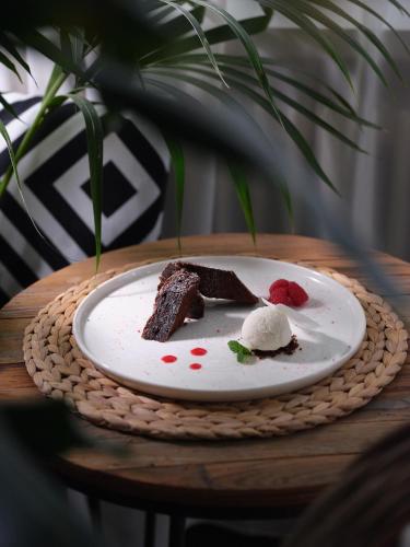 a plate with a piece of cake and ice cream on a table at Hotel Sole in Cannero Riviera