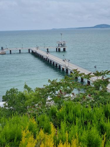 a pier in the ocean with people walking on it at Студио Бургас 2 in Burgas