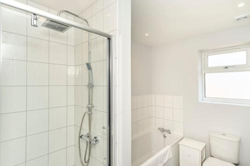 a white bathroom with a shower and a toilet at *Malt House* a Cosy Family Seaside Hideaway in Ventnor