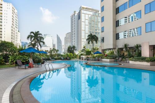 a swimming pool in the middle of a city with tall buildings at Rembrandt Sukhumvit - SHA Extra Plus in Bangkok
