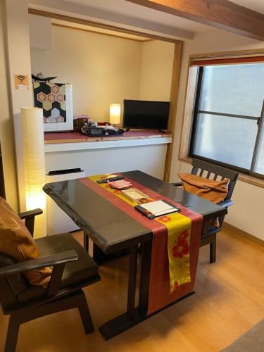 a living room with a table and chairs and a window at KAZEMACHIOYADO RAMUYA 〜風待ち御宿　来夢や〜 in Shimoda