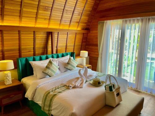 a bedroom with a bed with a large window at Abian Klumpu Villa & Spa Sanur Bali in Sanur