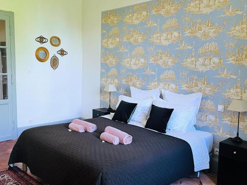 1 dormitorio con 1 cama con 2 almohadas rosas en Le Domaine de Villespy, en Villespy