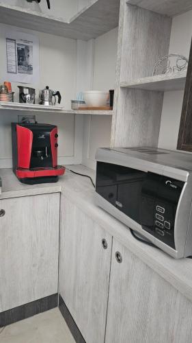 una cucina con un forno a microonde sopra un bancone di Vela Apartment a Durrës