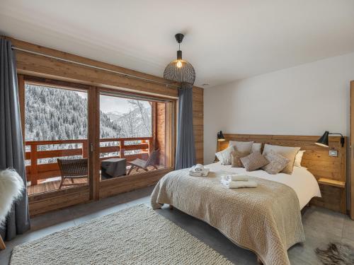 シャテルにあるBois Colombes n5 - Chalet - BO Immobilier - Châtel- remises sur les forfaits de skis Châtel ou Portes du soleilのベッドと大きな窓のある寝室