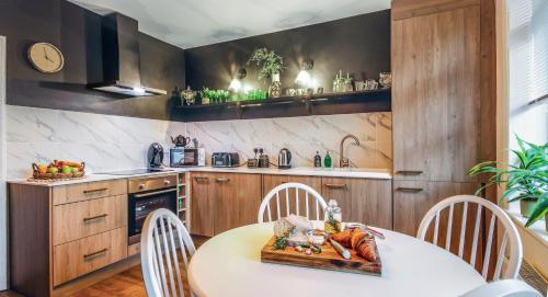 a kitchen with wooden cabinets and a table and chairs at KIRA Beach Apartment, Hove Beach in Hove
