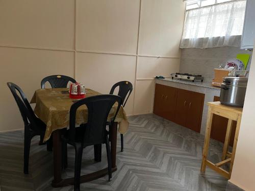 een eetkamer met een tafel en stoelen in een keuken bij Keeon Private Room Front in Shillong