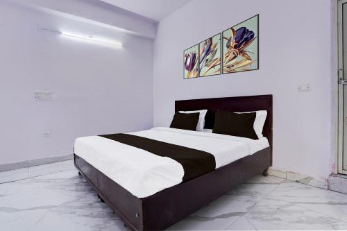 Kālkāji Devi的住宿－OYO Hotel Wamson，一间白色客房内配有一张大床的卧室