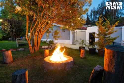 a fire pit in a yard with a tree at StayVista at The Alcove with Breakfast & BBQ Grill in Ooty