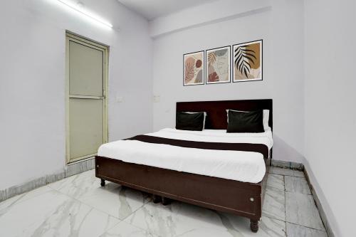 Kālkāji Devi的住宿－OYO Hotel Wamson，一间白色客房内配有一张大床的卧室
