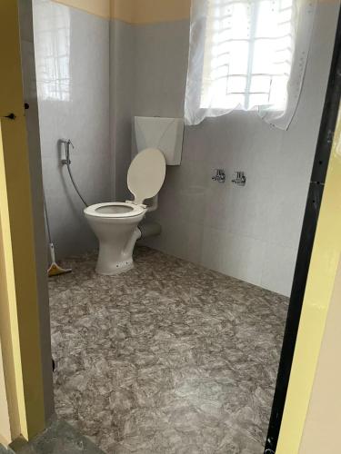 een badkamer met een toilet en een raam bij Keeon Private Room Front in Shillong