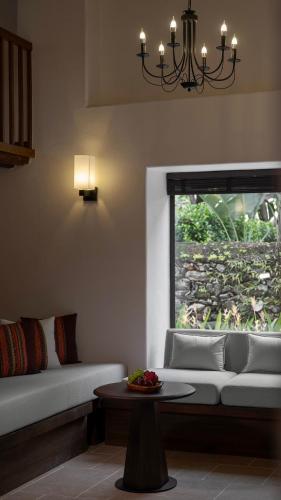 a living room with a couch and a window at Sanhe Daoli Resort in Qingyuan