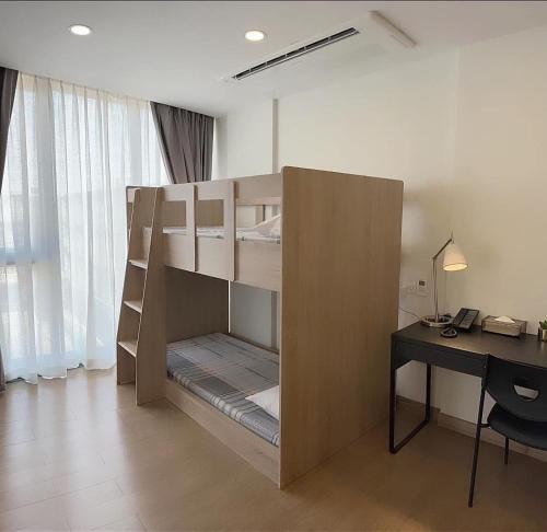 a bunk bed in a room with a desk at Canalis Suvarnabhumi Airport Hotel - Free Scheduled shuttle from Hotel to Suvarnabhumi Airport in Lat Krabang