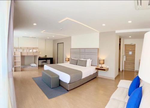 ein großes Schlafzimmer mit einem großen Bett und einem Schreibtisch in der Unterkunft Canalis Suvarnabhumi Airport Hotel in Lat Krabang