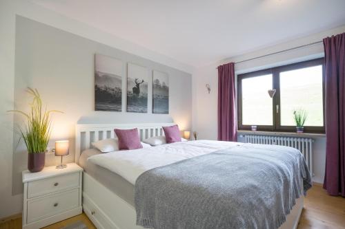 a bedroom with a large bed with purple curtains at Ferienwohnung Almwiesen in Obermaiselstein