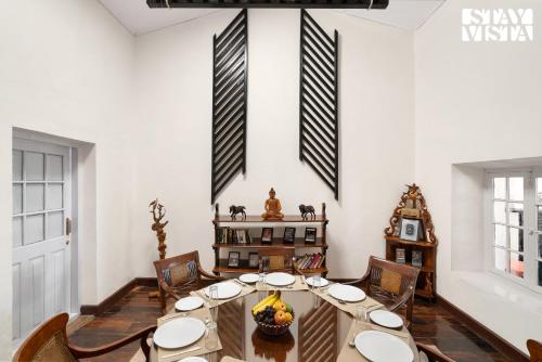a dining room with a table and chairs at StayVista at The Alcove with Breakfast & BBQ Grill in Ooty