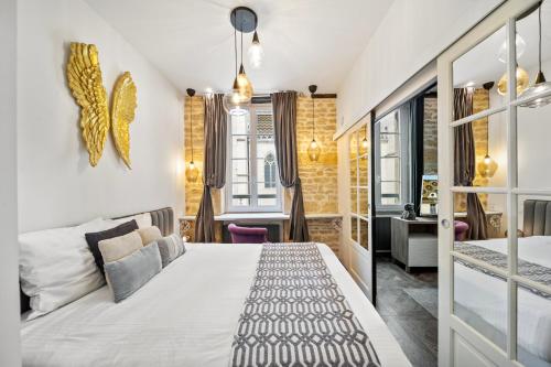 een slaapkamer met een groot bed en een bureau bij La Suite Indivio - Appartement standing vue cathédrale in Dijon