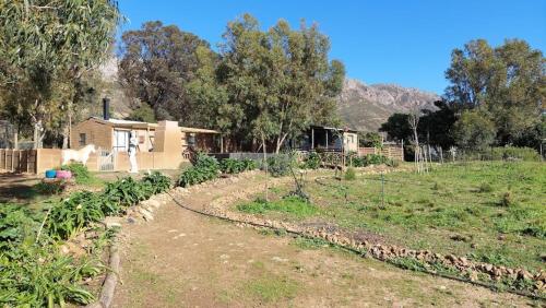 a garden with a house in the background at 11 Mountain Stream Hot Tub Self Catering in Gordonʼs Bay
