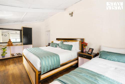 a bedroom with two beds and a window at StayVista at The Alcove with Breakfast & BBQ Grill in Ooty