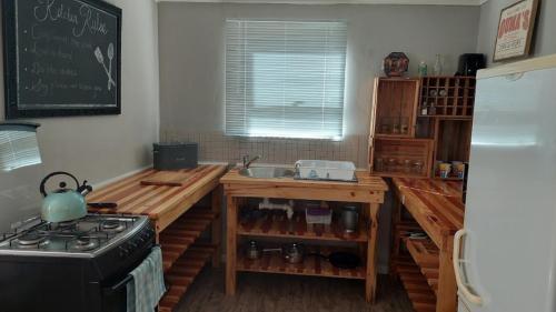 a kitchen with a counter with a sink and a stove at 11 Mountain Stream Hot Tub Self Catering in Gordonʼs Bay