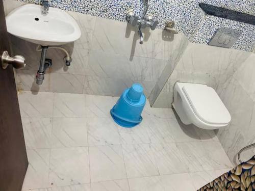 a bathroom with a toilet and a blue bottle on the floor at Goroomgo Golden Beach Inn Puri Near Sea Beach in Puri