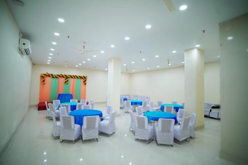 Habitación con mesas azules y sillas blancas. en icyhotels ADA residency and confrence centre, en Noida