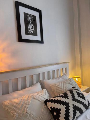 a bedroom with a bed with a picture on the wall at Pops art condo in Kampala