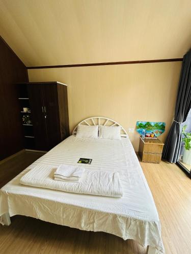 a bedroom with a large bed with white sheets at Son River House in Phong Nha