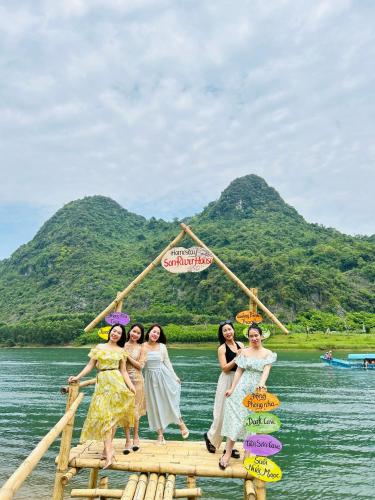 a group of women standing on a raft in the water at Son River House in Phong Nha