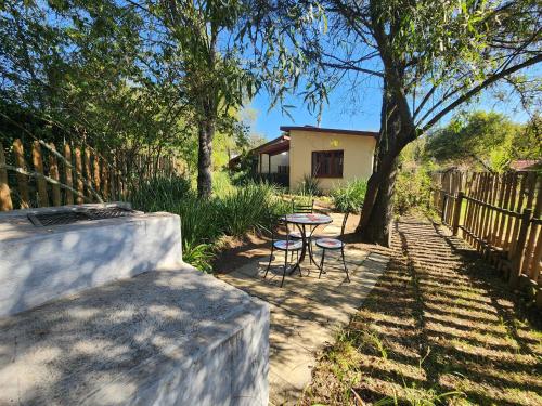 a patio with a table and chairs under a tree at Pine Valley in Lanseria