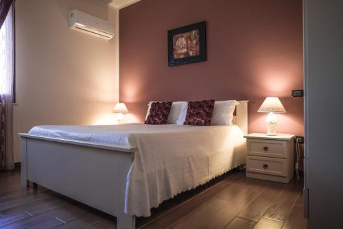 a bedroom with a large bed with two lamps on it at Casa Piano del Re in Partinico