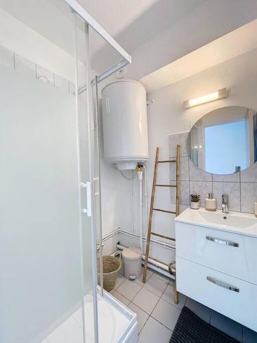 La salle de bains est pourvue d'un lavabo, d'un miroir et d'une échelle. dans l'établissement 3319-appartement à 200m de la plage, au Barcarès