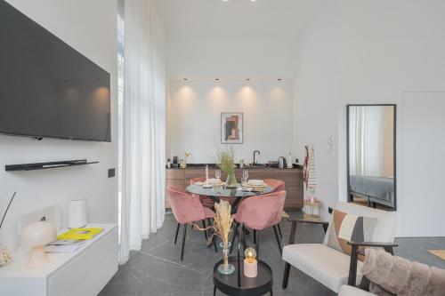 a living room with a table with pink chairs at Piccola Como Lotus by Rent All Como in Carate Urio