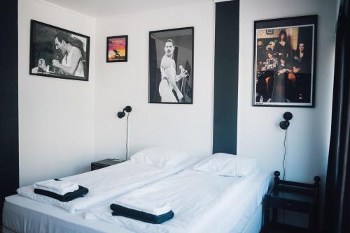 ein Schlafzimmer mit einem weißen Bett mit Bildern an der Wand in der Unterkunft Rock Hotel Salo in Salo