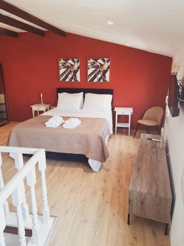 - une chambre dotée d'un lit avec un mur rouge dans l'établissement AtticStudioTheotoki, à Corfou